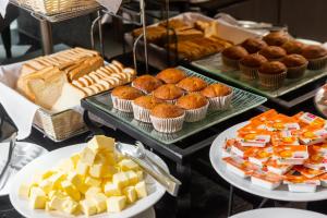 a buffet of food with pastries and muffins at SureStay Plus by Best Western Sukhumvit 2 in Bangkok