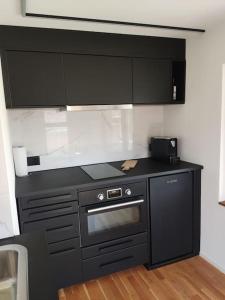 a kitchen with a black counter top and a stove at Mini Huus im schönen Thurgau in Schönenberg