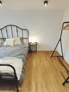 sypialnia z łóżkiem i drewnianą podłogą w obiekcie Mini Huus im schönen Thurgau w mieście Schönenberg