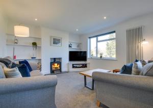 uma sala de estar com dois sofás e uma lareira em Sandpipers em Rottingdean