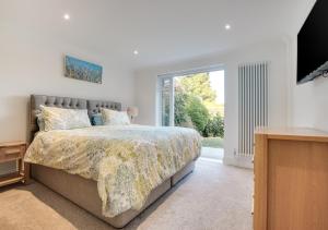 um quarto com uma cama e uma grande janela em Sandpipers em Rottingdean