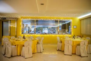 a dining room with tables and chairs with yellow walls at Hotel Residence Federiciano in Valenzano