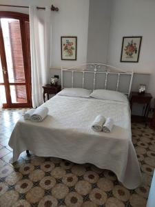 a bedroom with a white bed with two towels on it at Arenella Beach Rooms in Arenella