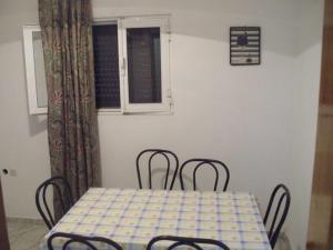 a table and chairs in a room with a table and a window at Adriana Saina Apartments in Agios Georgios