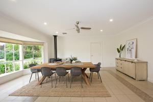 a dining room with a wooden table and chairs at Seppeltsfield Vineyard Retreat - 3 Bedroom Holiday Home in Seppeltsfield