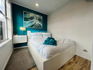 a bedroom with a bed with a blue accent wall at Tiny House in Belconnen 1BR Self Contained Wine in Higgins