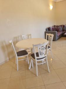 a table and chairs in a living room with a couch at Appartement Al hoceima in Al Hoceïma