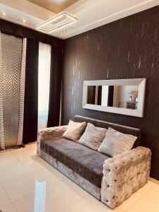 ブダペストにあるSilver Apartmentのソファ付きのベッドルーム1室、壁に鏡が備わります。