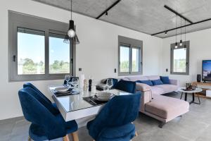 a living room with a dining table and blue chairs at Villa Beato in Preveza