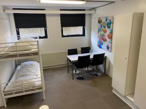 a dorm room with a desk and bunk beds at Family rooms in the center in Grindsted