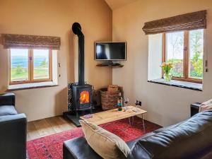 a living room with a wood stove and a couch at The Old Byre in Upper Hulme