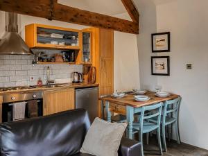 una cucina con tavolo, sedie e piano di lavoro di The Old Byre a Upper Hulme