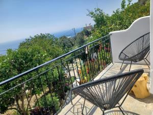 a bench on a balcony with a view of the ocean at Vlami's House Andros in Apróvaton