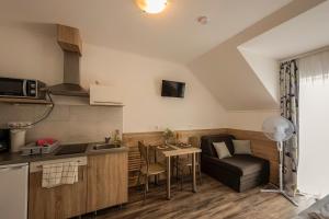 a small kitchen with a table and a couch at Kikötő Apartmanok in Balatonboglár