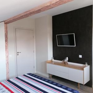 a bedroom with a tv on a black wall at Apartments Dona in Chernomorets