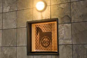 a window in a brick wall with a clock in it at Richmond Hotel Yokohama-Bashamichi in Yokohama