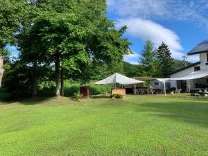 einen Hof mit Zelten und einem Haus und einem Baum in der Unterkunft Lakeside Hotels Kuore in Kitashiobara