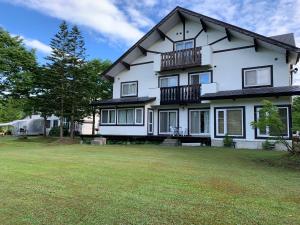 ein großes weißes Haus mit einem großen Hof in der Unterkunft Lakeside Hotels Kuore in Kitashiobara