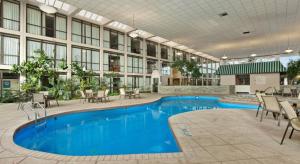 a large pool in a building with tables and chairs at Days Inn by Wyndham Columbus Airport in Columbus