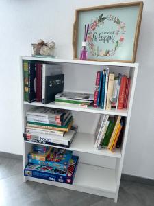 a white book shelf filled with books at SO Apartment Steyr in Sankt Ulrich bei Steyr