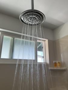 una ducha con agua colgada del techo en Kailani Loft, Kailua Coconut Grove 1-bedroom, en Kailua