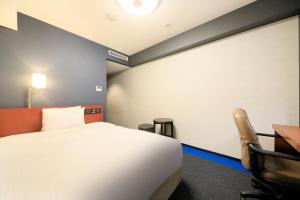 a hotel room with a bed and a desk at Richmond Hotel Yokohama-Bashamichi in Yokohama