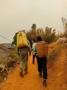 a group of people walking down a dirt road at Indigenous homestay 1- Trek- Vegetarian- Bus in Yên Bái