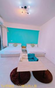 1 dormitorio con 2 camas y una mesa en el centro en Funshine B&B, en Magong