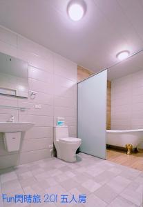ein Badezimmer mit einem WC, einem Waschbecken und einer Badewanne in der Unterkunft Funshine B&B in Magong