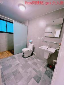ein Bad mit einem WC und einem Waschbecken in der Unterkunft Funshine B&B in Magong
