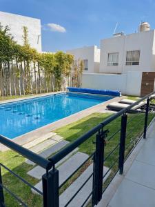uma piscina no meio de um edifício em Acogedora y amplia casa, alberca climatizada previa reserva em Juriquilla
