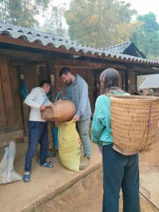 a group of people standing outside a building with a basket at Indigenous homestay 1- Trek- Vegetarian- Bus in Yên Bái