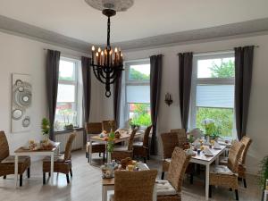 a dining room with tables and chairs and windows at Townhuus No. 1 / Dieksee in Malente