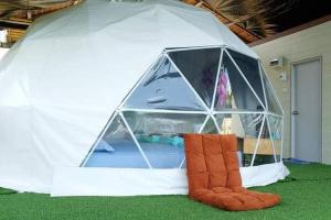 a tent with a bed in it on the grass at Chill chill homestay in Ban Khao Thalu +12 photos