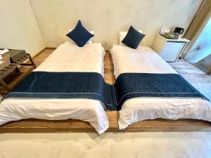 two beds sitting next to each other in a room at Enfield一宮 in Ichinomiya