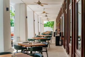 eine Reihe von Tischen und Stühlen in einem Restaurant in der Unterkunft Wings by Croske Resort Langkawi in Pantai Cenang + 37 Fotos