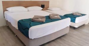 Duas camas individuais num quarto com duas toalhas em Burdekin Motor Inn em Home Hill