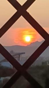 a view of a sunset through a window at Airport at 25 min by walk - 5 min by walk to commercial center 2 min by walk to touristic port for trip to islands 5 min by walk to bus for city and beaches -Balcony sunset and Sea view-wi fi-air cond-5 persons-pool from 15 june to 15 september PISCINA in Olbia