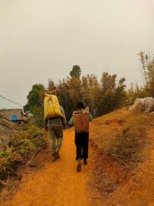 Mù Cang Chải的住宿－Indigenous homestay- Trek- Food- Bus，走在土路的两个人
