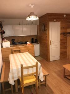 a kitchen with a table and a table and chairs at Studio front de neige - pieds des pistes in Enchastrayes