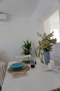 a white table with blue plates and plants on it at Casa Keko in La Herradura