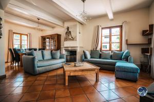 a living room with blue couches and a table at Villa le Thor Piscine Billard Sauna et Jacuzzi in Le Thor