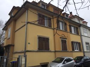 a yellow house with cars parked in front of it at Mury 12 in Strasbourg