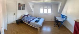 a bedroom with a bed and a desk and a window at Mury 12 in Strasbourg