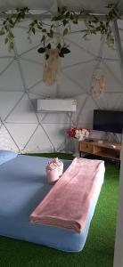 a bed in a tent with a pink blanket on it at Chill chill homestay in Ban Khao Thalu