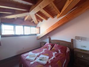 a bedroom with a bed in a room with wooden ceilings at Romántico acogedor apartamento en Llanes (Montaña) in Llanes