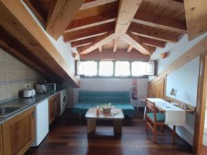 a kitchen and living room with a couch and a table at Romántico acogedor apartamento en Llanes (Montaña) in Llanes
