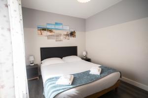 - une chambre avec un lit et 2 serviettes dans l'établissement Le Cabestan, appartement proche plage Morgat, à Crozon