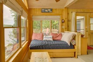 Bett in einem Zimmer mit Fenster in der Unterkunft Waterfront Raymond Vacation Rental with Boat Dock! in Raymond