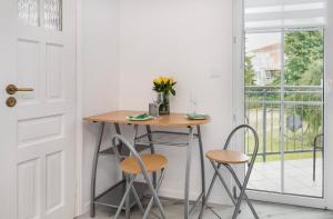 a table and chairs in a room with a window at Apartament Hexagon nr 10 in Grzybowo